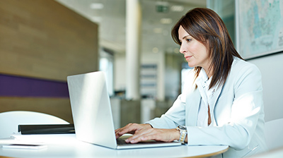 A businesswoman working on a laptop.