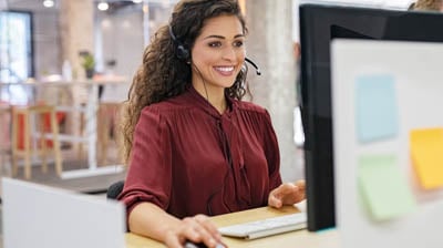 Customer support phone operator working at computer.