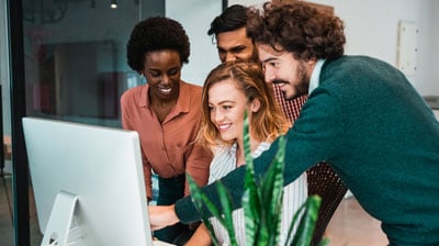 Shot of a group of colleagues using computer together at work.