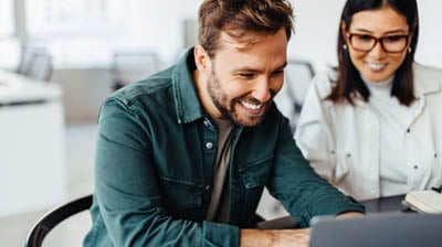 Successful business man using a laptop in a meeting with his colleague.