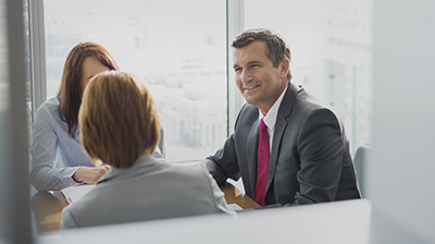 Man talking to two women in business attire